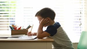 Escritorio infantil con agenda, lápices y cuaderno ordenados, iluminado por luz natural cálida.