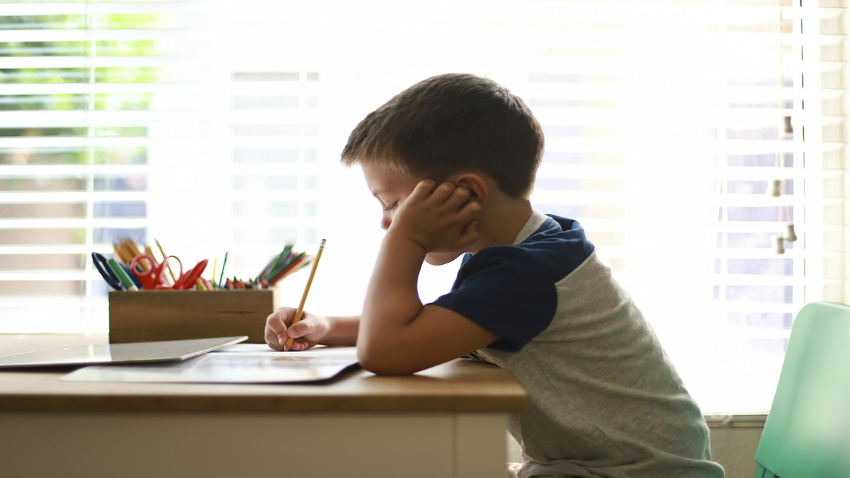 Escritorio infantil con agenda, lápices y cuaderno ordenados, iluminado por luz natural cálida.